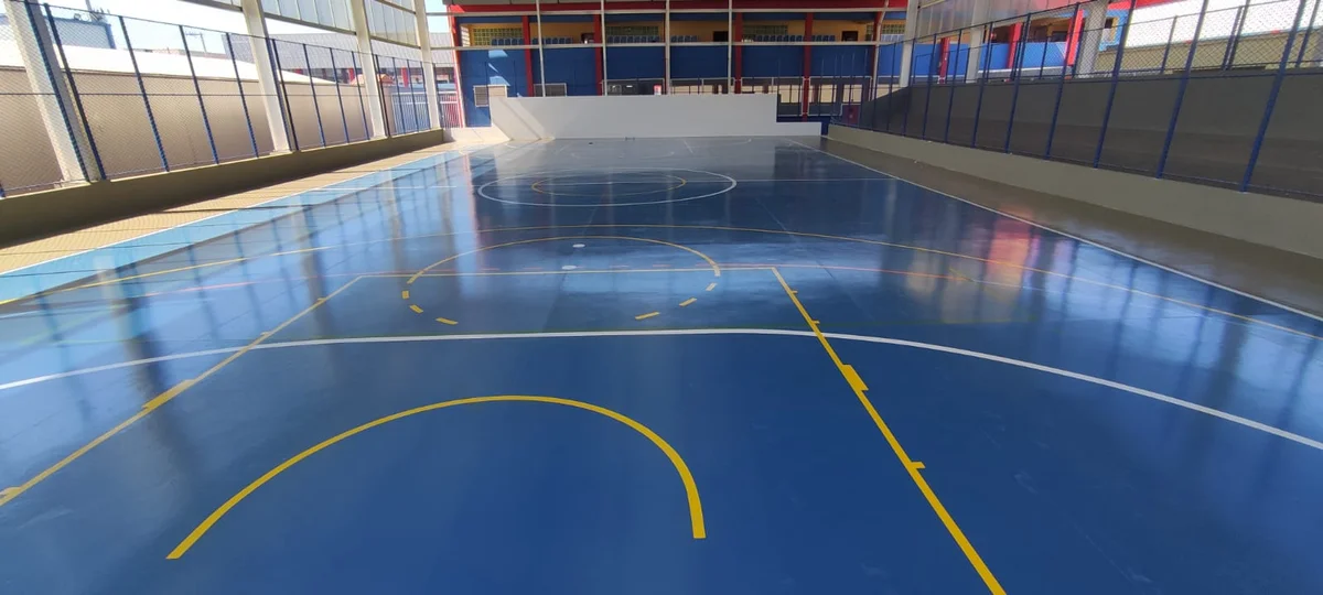 Quadra esportiva reconstruída com piso de concreto e demarcação