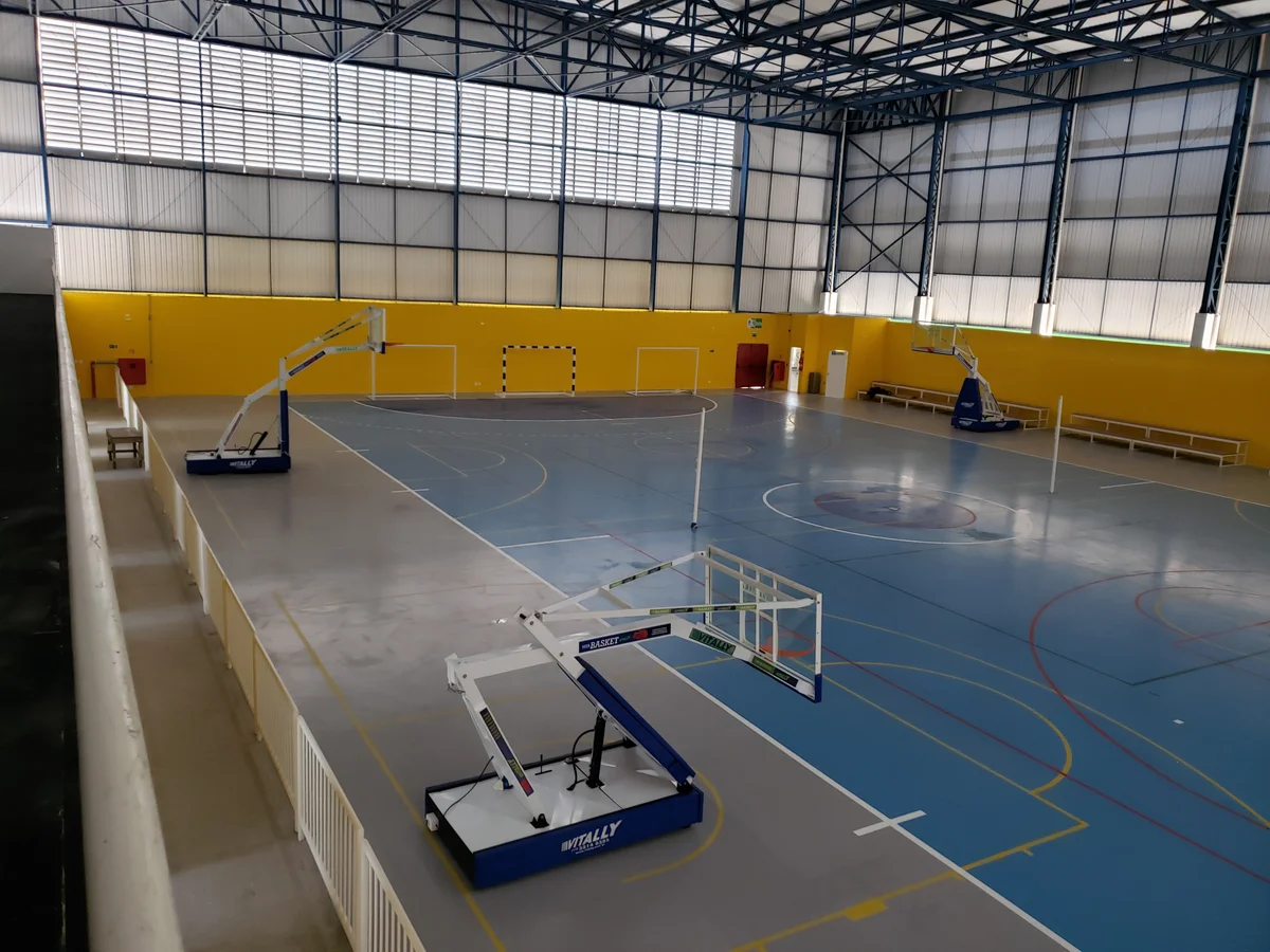 Arquibancada e tabela de basquete móvel no ginásio