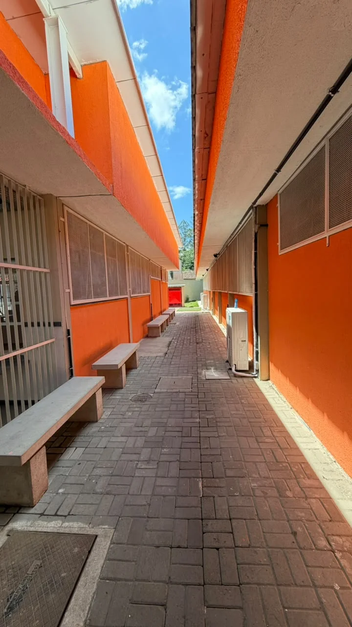 Corredor externo coberto com bancos de concreto