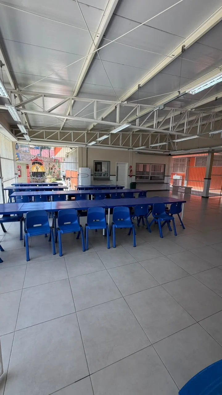 Refeitório coberto com estrutura metálica e guichês de atendimento